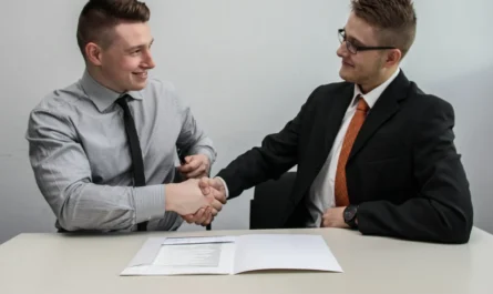 Employer and new hire shaking hands after a sponsored job offer that meets the Skilled Worker visa salary threshold