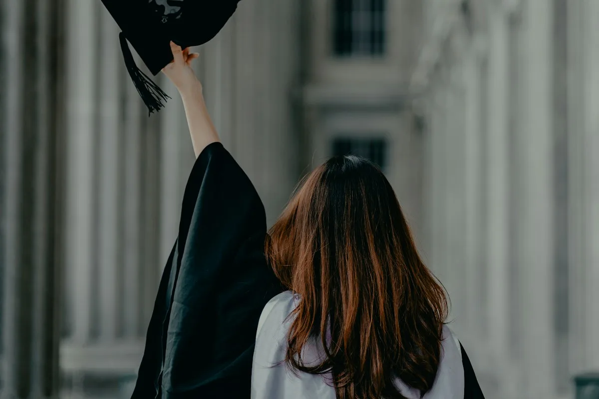 Graduate in cap and gown, showing what a scholarship can pay for
