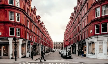 People walking on a London street between red brick buildings